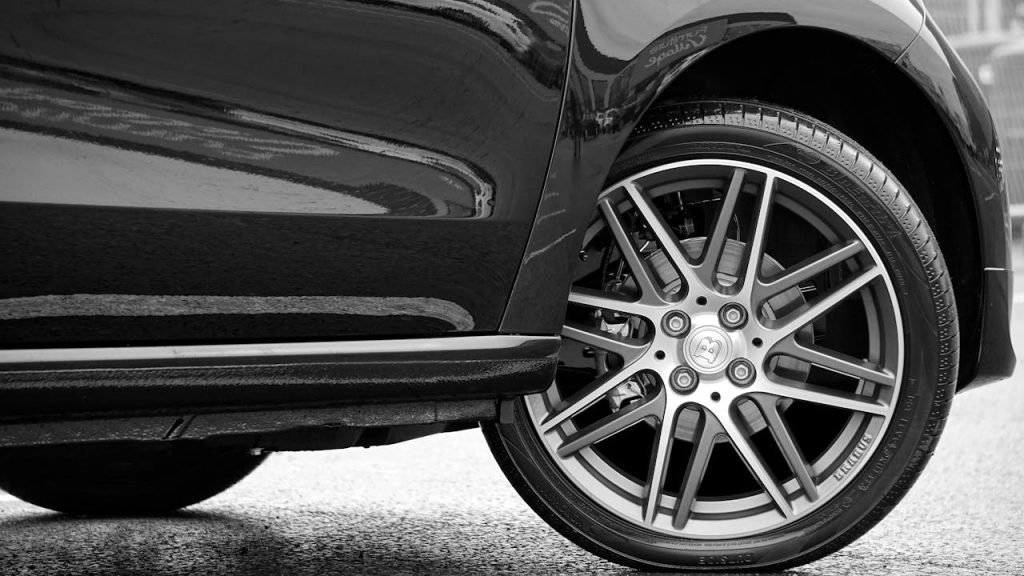 Close-up of a car wheel with a stylish rim design in black and white.